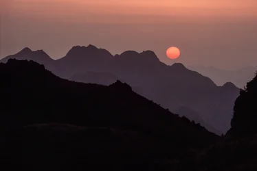 鮮やかな紅色とオレンジ色の太陽が燕山山脈に沈む。山海関峠、...