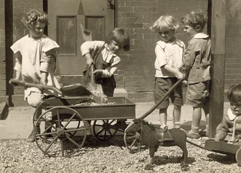 幼児が砂利をカートに入れる、1915年頃（写真）