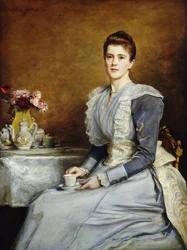 1891年に灰色と白のドレスを着て、ティーテーブルに4分の3の長さで座ったジョセフチェンバレン夫人の肖像