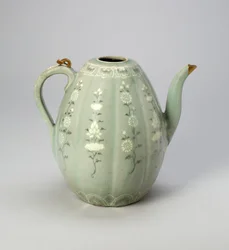花卉文様メロン形皿（青磁釉を施した石器に、黒と白の粘土で象嵌した装飾を施したもので、金の修理が施されています。