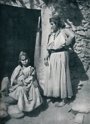 1912年、アルジェリアの地中海沿岸近くの住居の玄関にいるカビールの女性。