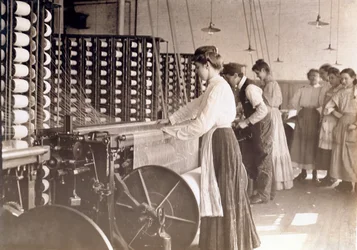1908年、サウスカロライナ州の綿工場の紡績機で働く若い女性