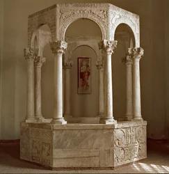 中世の考古学（Middle Ages）。ロンバルディア州の蛮族芸術：総主教カリストの洗礼源（バプティステレ）は、横のアーチとコリント式の円柱で構成された八角形の形をしています。730～740年の建築。ロンバルディア美術、8世紀石灰岩。彼