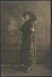 [タペストリーの前に長いコートを着た女性の肖像]。