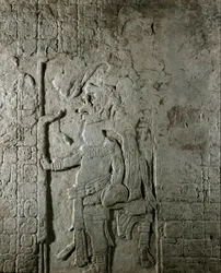 マヤ美術：エル・カヨのマヤ遺跡から出土したパネルNo.1（600～800年頃）には、天文学的計算を示すヒエログリフの文字に囲まれたキャラクターが描かれています。個人蔵