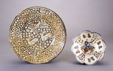 14世紀の密な緑豊かなモチーフの中に座っている2頭の鹿を描いたスルタナバードの陶器料理