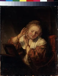 イヤリングを試着している若い女性。 イヤリングを試着している若い女性。 レンブラント (1606-1669) として知られる Harmenszoon van Rijn の絵画