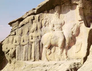帽子に紋章を付けたシャプールI（AD 241-272）とその家族を描いた岩のレリーフ（写真）