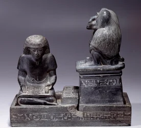 エジプトの古代遺跡。書記のネブマートゥフと、経典の神で書記の守護神である猿のトート。シェールの彫刻。アメノフィス3世の時代（1391〜1353年