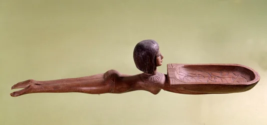 エジプト古代美術：アヒルを持つ裸の泳ぐ女性をかたどった化粧用木製スプーン。第18王朝、新王国時代。パリ、ルーヴル美術館
