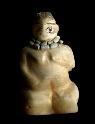 下部メソポタミア、イラク、シュメール美術：テル・エス・サワン遺跡出土のひざまずく女性のアラバスター小像。紀元前3000年。寸法：9.4センチメートル。バグダッド、イラク国立博物館