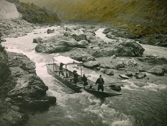 1900～1915年頃、京都・保津川の急流に浮かぶ舟（写真）。