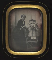 母と一緒に花を抱えて椅子に立っている子供c。 1855。
