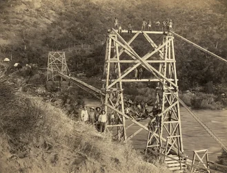 カリフォルニア州フレズノ：1890年。C.C.カーティスによるこの写真は、キングス川に架かるスミス・アンド・ムーア橋を写している。この橋は、ハイラム・T・スミスとオースティン・D・ムーアが自社キングス・リバー・ランバーのためにシエラ山脈から木材を運ぶ目的で建設した水路の一部である。