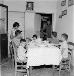 カントリーハウスのダイニングルームのテーブルで再会する大家族。1960s
