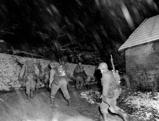 第二次世界大戦（1939-1945） - World War II（WWIIまたはWW2）。ランゲフォッセ地方（ヴォージュ地方） 1944年11月。吹雪の中、戦線から帰還するアメリカ第7軍第36DIの142RIの歩兵たち