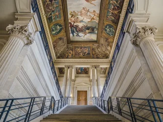 階段は、建築家シャルル・ルロン（1793-1861）とエドゥアール・デュボア（1795-1813）によるもので、1840年から1846年にかけて制作されました。天井には、フェリックス・ジョッブ・デュヴァル（1821-1889）が描いた「黎明期にアーカイブを取り付けるフランス」（1877年から1881年の間）が描かれています。ホテル・ドゥ・スービズ