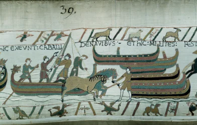 1066年、ノルマンディー公ウィリアム・ザ・コンカーラント（1027-1087）によるイングランドの征服：ノルマンディーの船がイングランドの海岸を航行している。馬が廊下で船を引いています。バイユー・タペストリーまたはマチルド王妃の刺繍の詳細